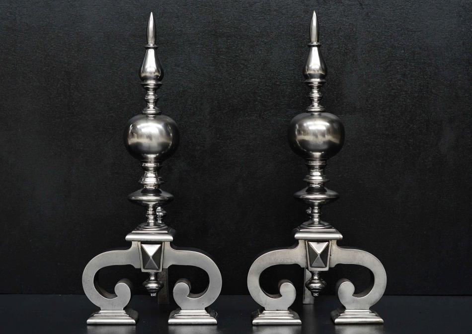 A large pair of antique polished steel firedogs