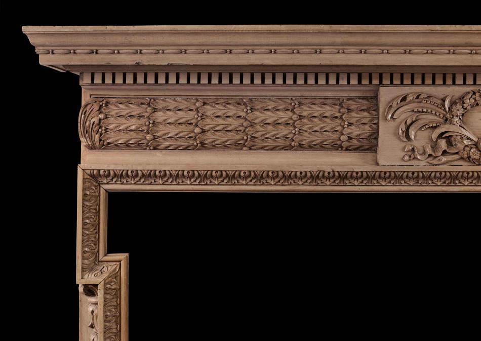 A well carved English pine fireplace with barrell frieze and oak leaves