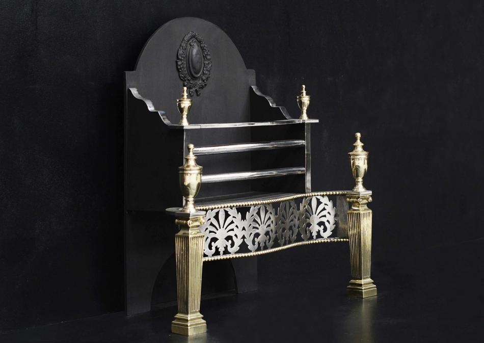 A brass and steel fire basket with Ionic capitals