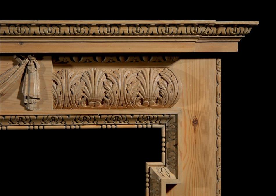 A carved pine fireplace with lion's mask and drapery