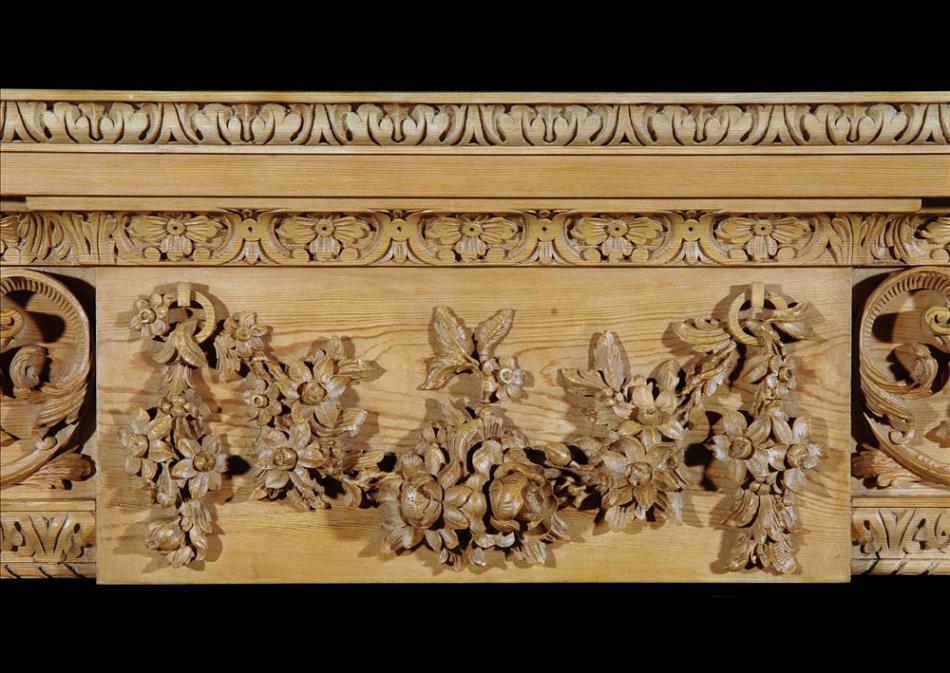 A carved English George III style pine fireplace