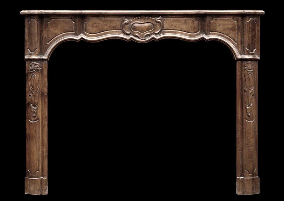 An elegant walnut French Louis XV style fireplace
