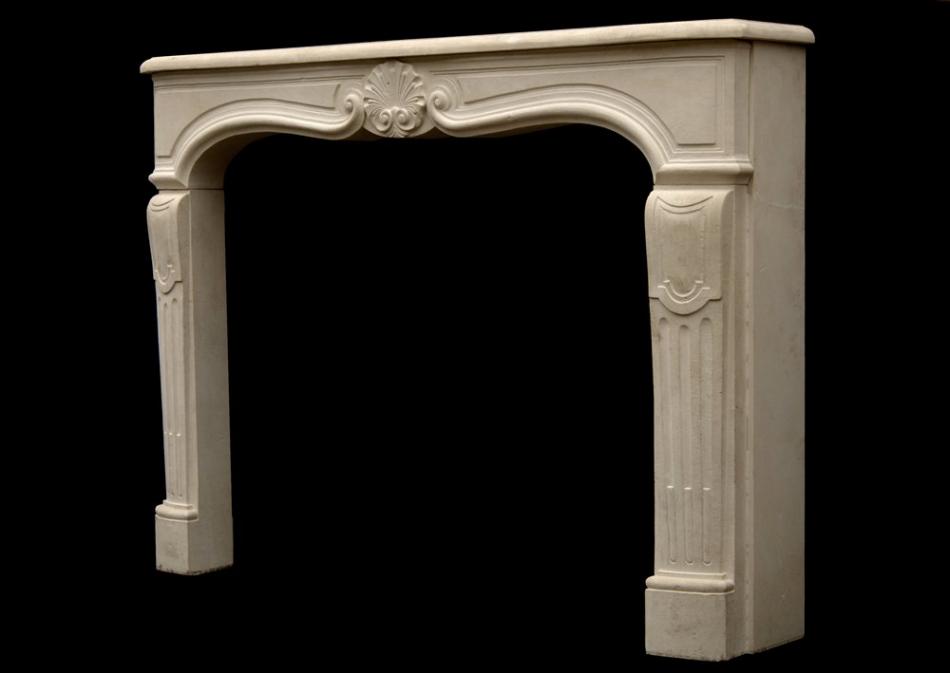 A 20th century Louis XV style limestone fireplace