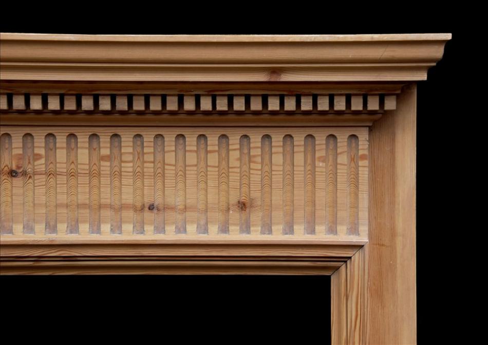 An English pine fireplace with fluted frieze
