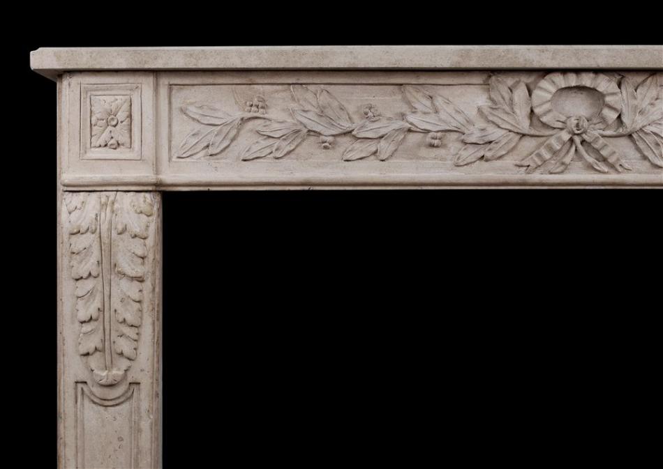 An  ornately carved French limestone fireplace in the Louis XVI style