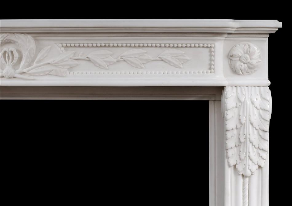 A carved French Louis XVI style white marble fireplace