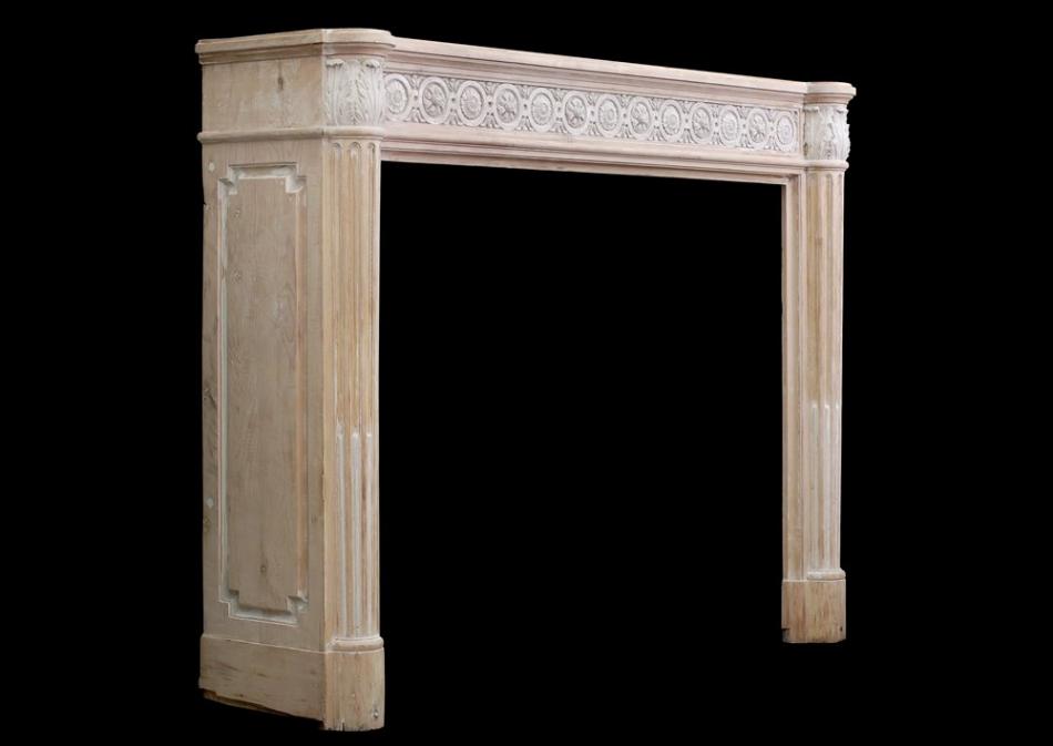 A French Louis XVI style wood fireplace with composition enrichments