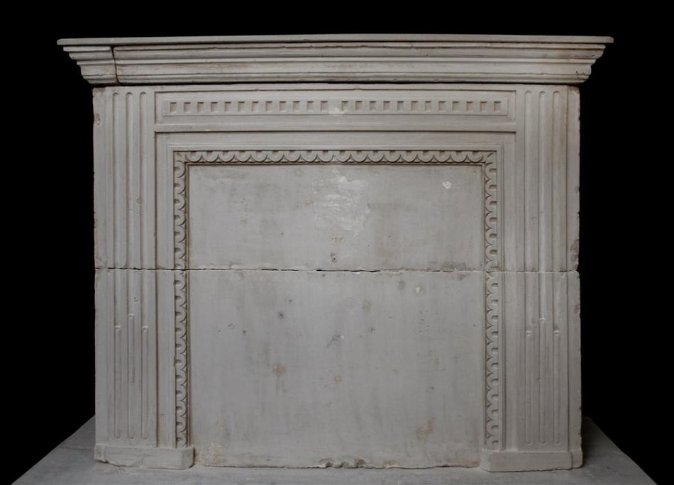 A late 18th century French Louis XVI limestone fireplace with trumeau