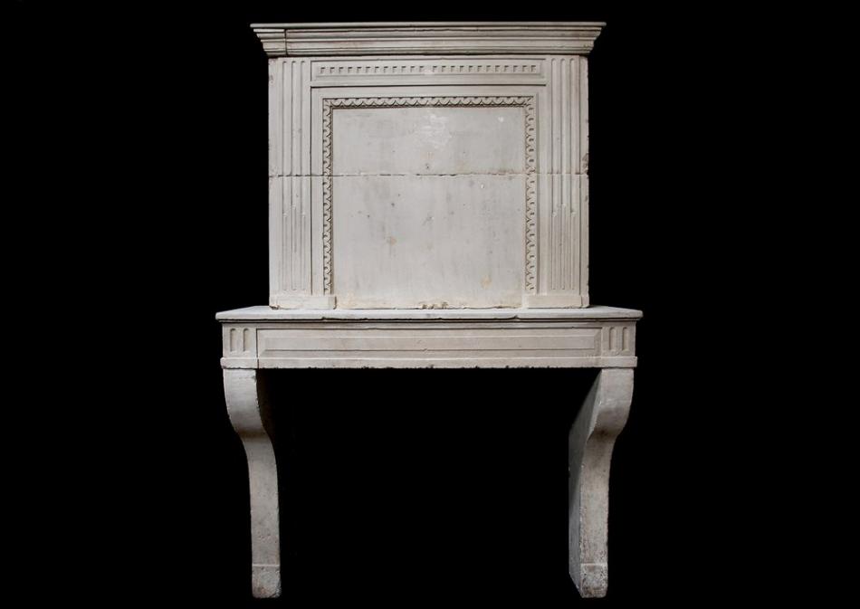 A late 18th century French Louis XVI limestone fireplace with trumeau
