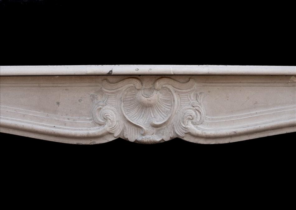 A 19th century French Louis XV style limestone fireplace