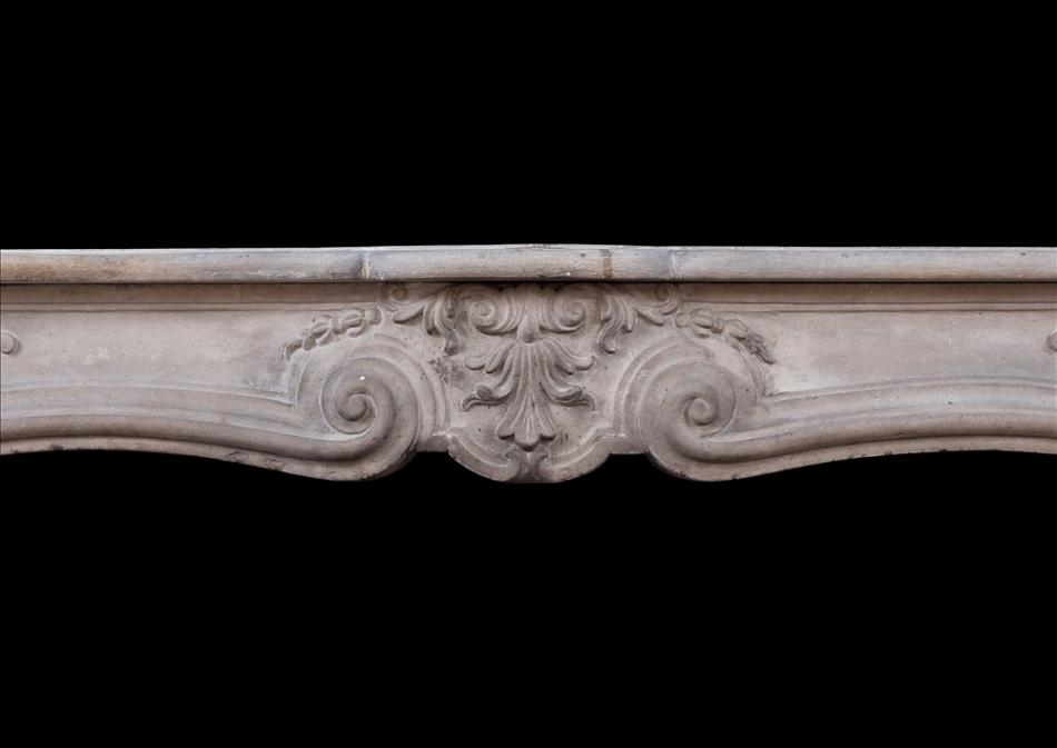 An antique French Louis XV limestone fireplace. 18th century