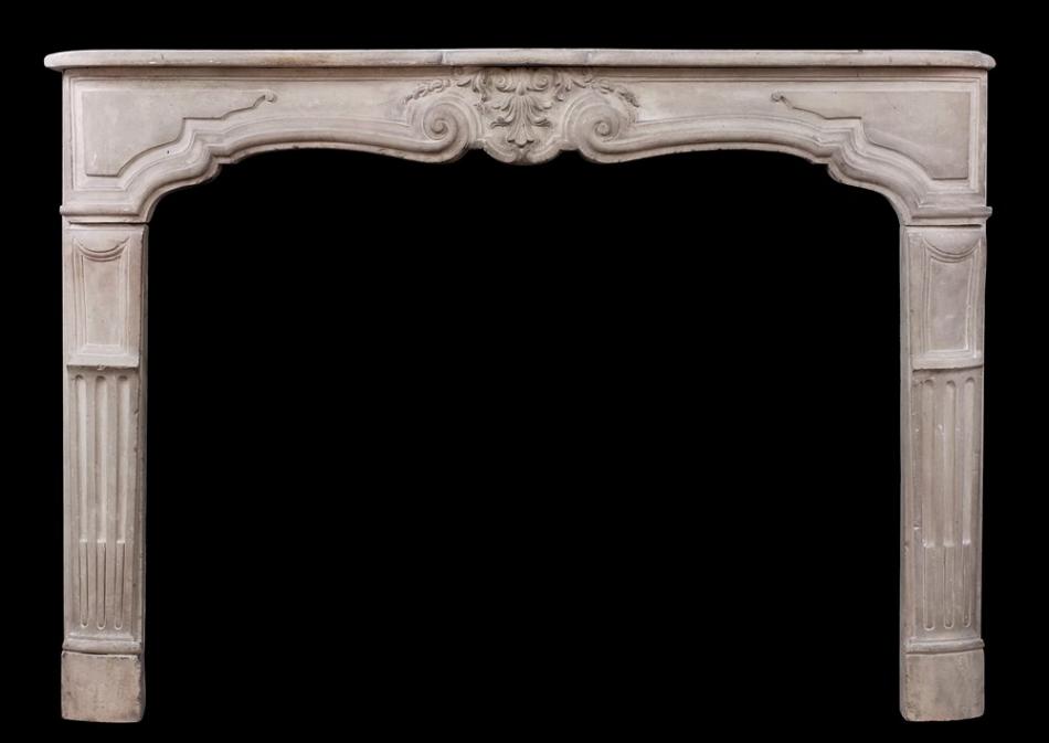 An antique French Louis XV limestone fireplace. 18th century