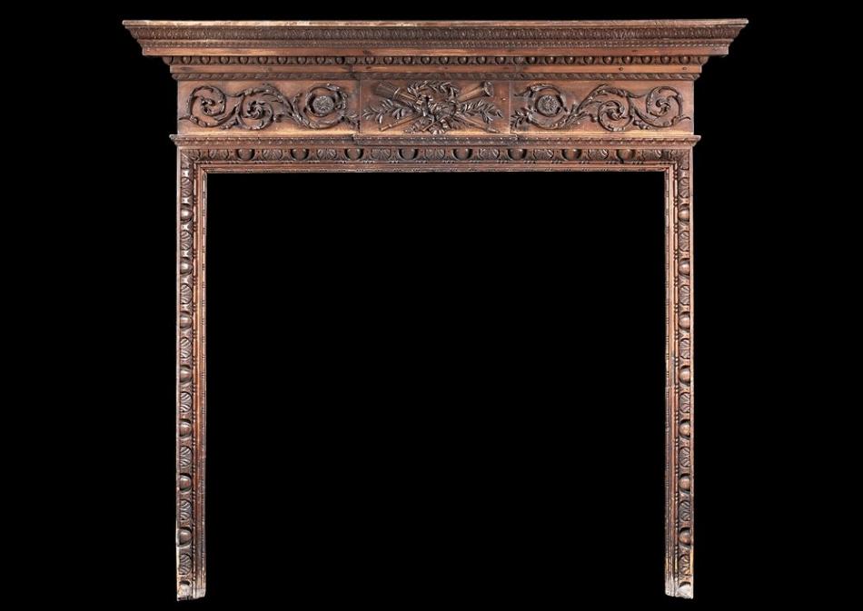 A late 18th century carved pine English fireplace