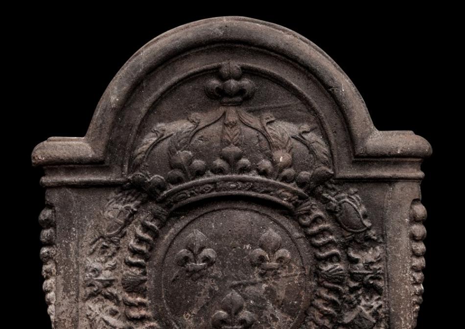 A large, decorative antique cast iron fireback