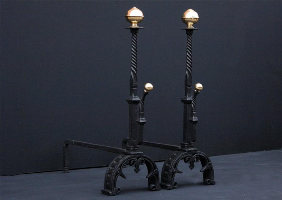 A pair of wrought iron firedogs with barley twist shafts