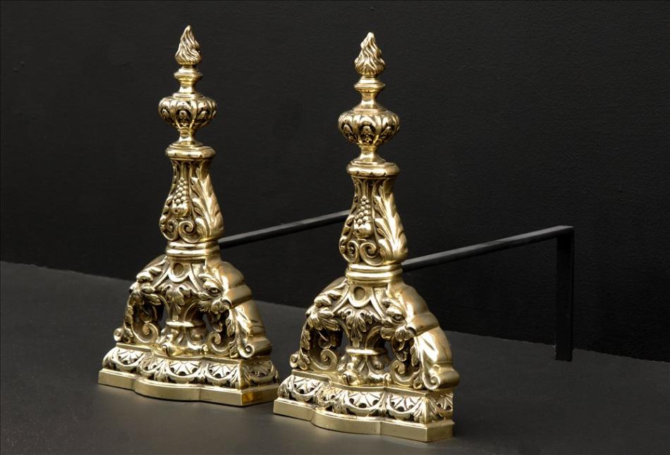 A pair of decorative brass firedogs