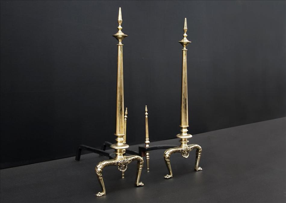A pair of tapering brass firedogs