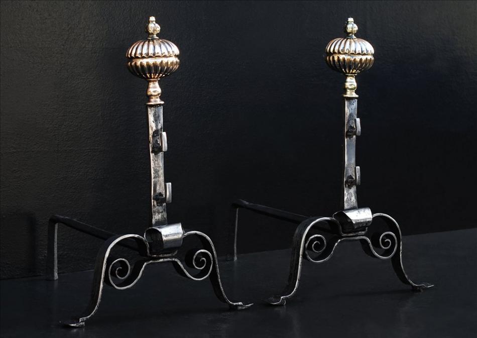 A pair of English polished steel firedogs with brass finial