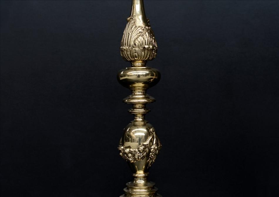 A large pair of ornate brass firedogs