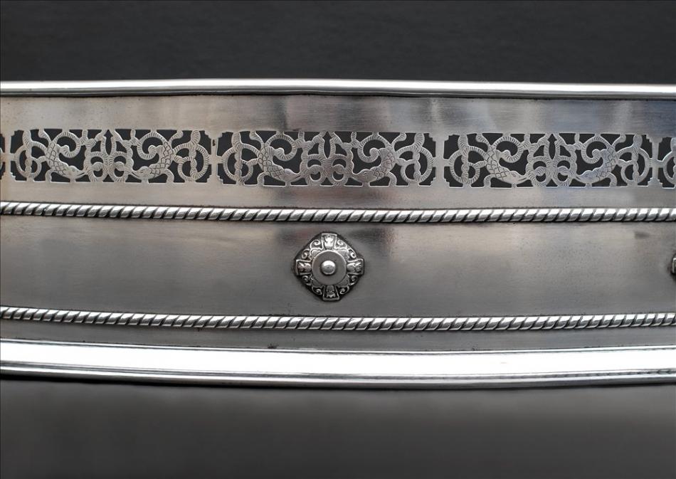 A polished steel pierced fender in the Georgian style