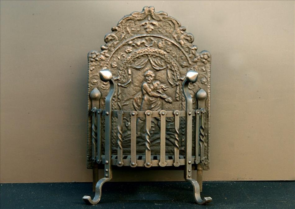 A 19th century wrought iron firegrate with decorative cast fireback