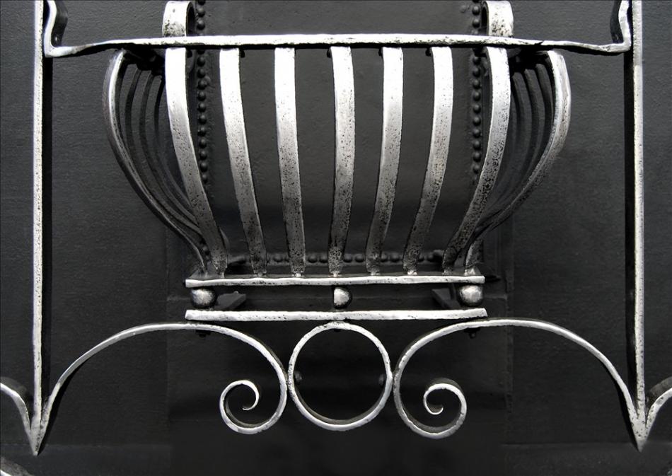 An Art Nouveau firegrate with scrolled legs and uprights