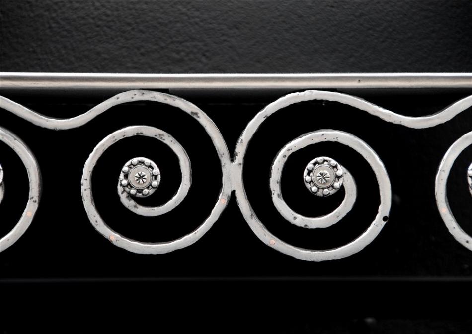 An English Arts and Crafts polished iron firegrate
