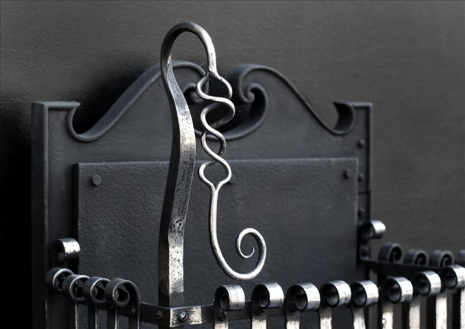 An Arts and Crafts polished wrought iron firegrate