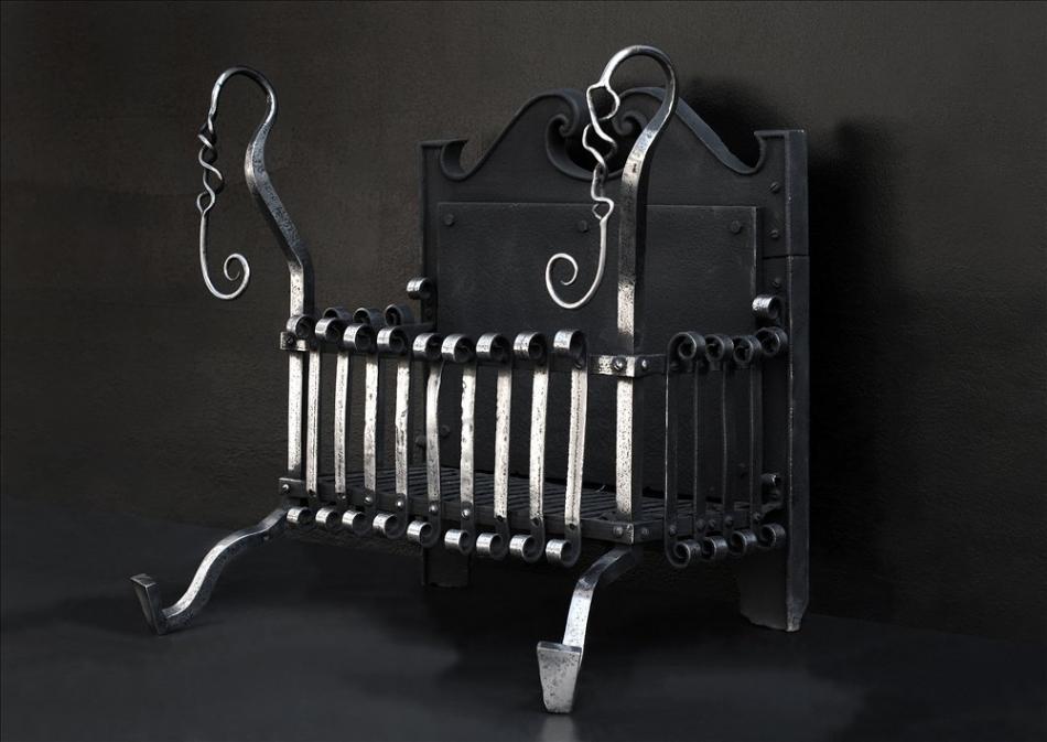 An Arts and Crafts polished wrought iron firegrate