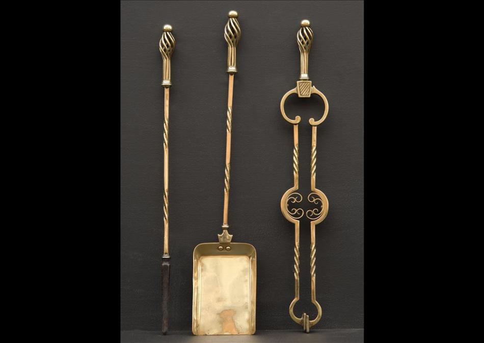 A set of late 19th century Arts and Crafts brass firetools