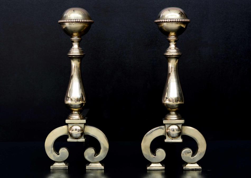 A pair of polished brass firedogs with beading to top