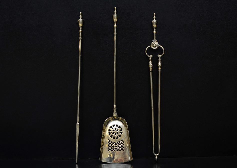 A set of brass firetools with pierced shovel