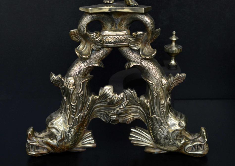 A large pair of brass firedogs with cherubs