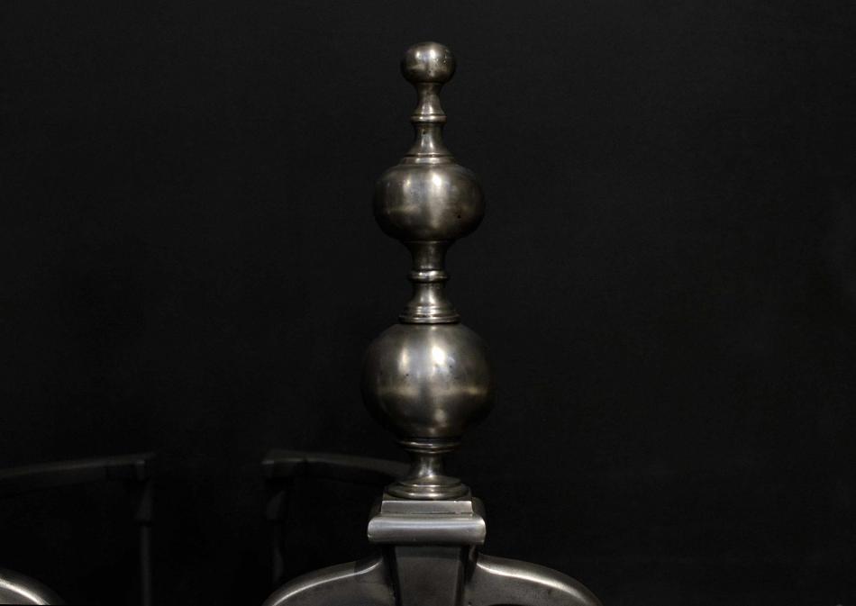 A pair of 19th century polished iron firedogs