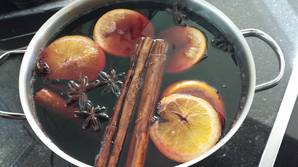 Wine, oranges and spices mulling in a pan
