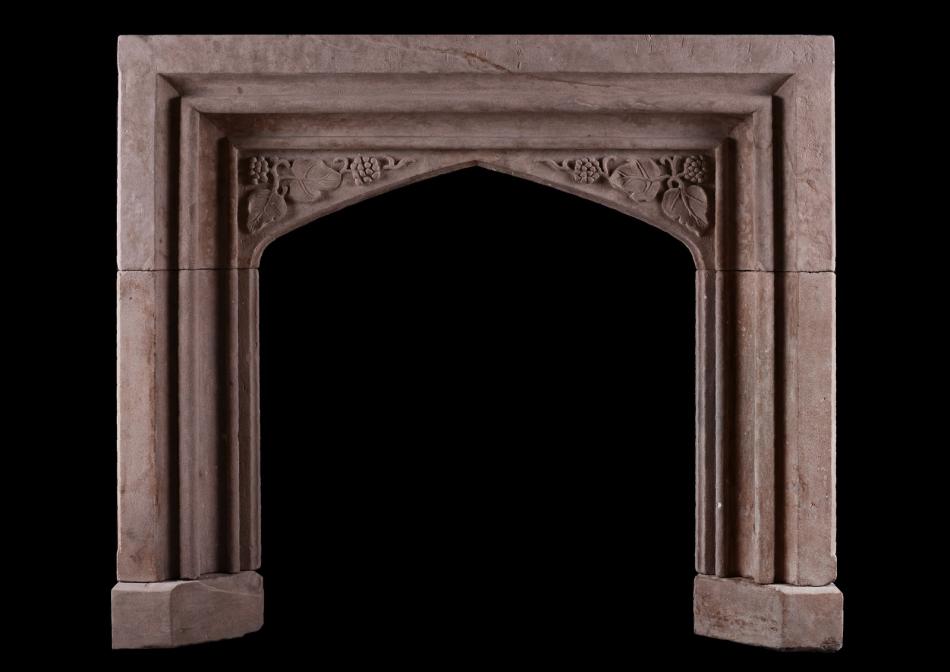 A carved stone fireplace in the Gothic manner