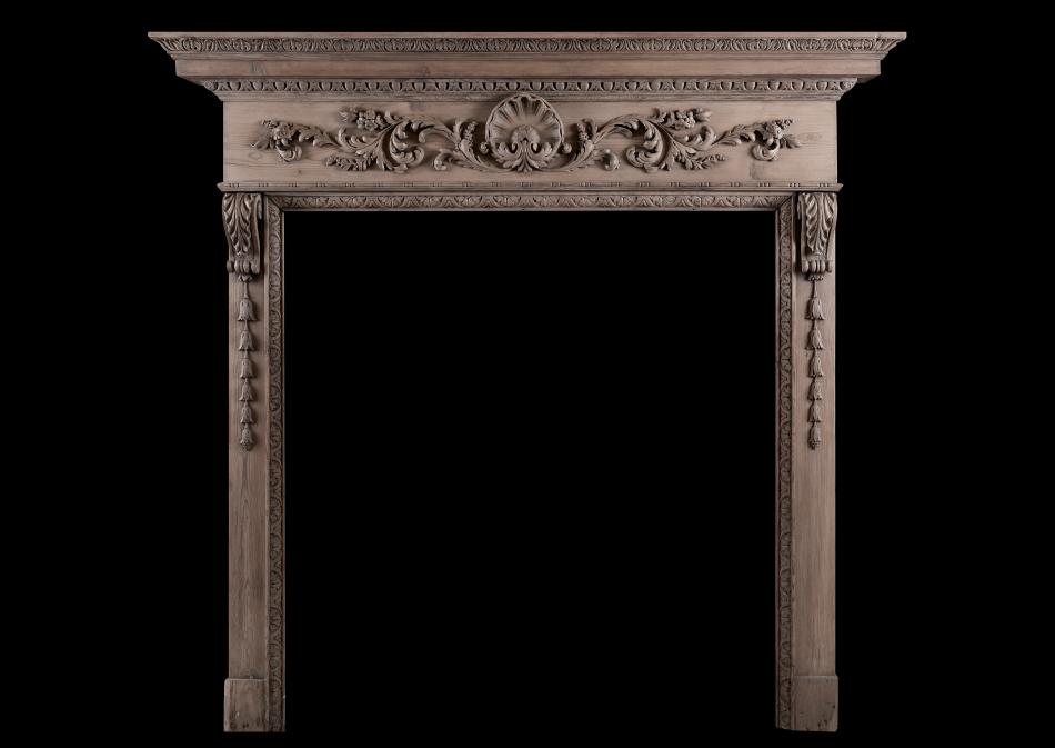 A carved pine fireplace with shell to centre