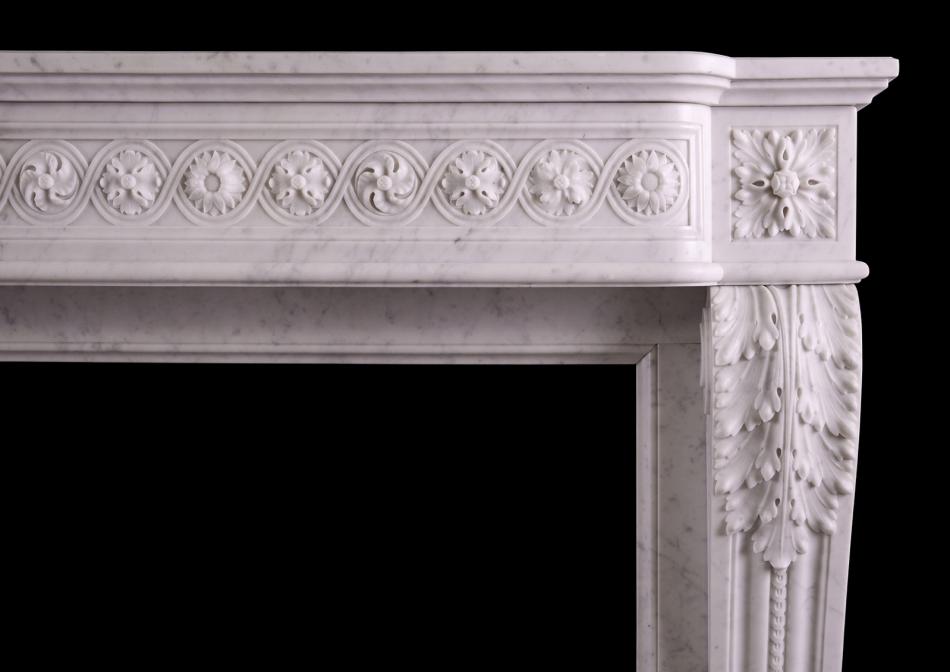 A carved marble fireplace in the Louis XVI manner