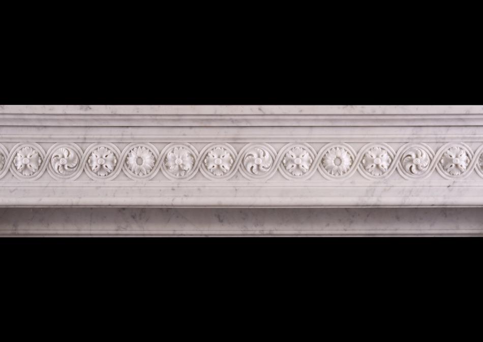 A carved marble fireplace in the Louis XVI manner