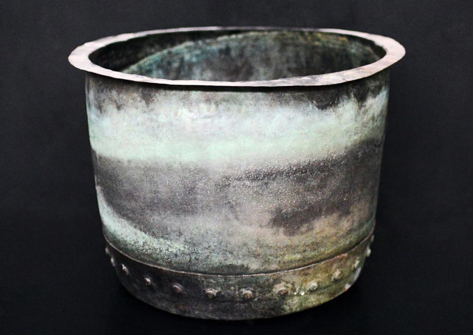 A large copper coal bucket with verdigris patination