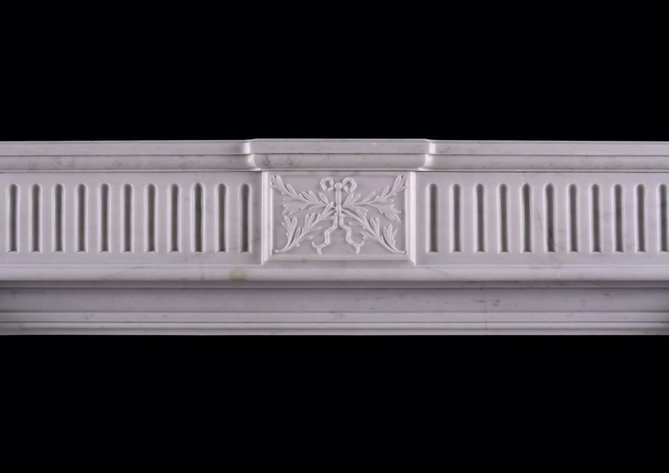 A carved Carrara marble fireplace in the Louis XVI manner