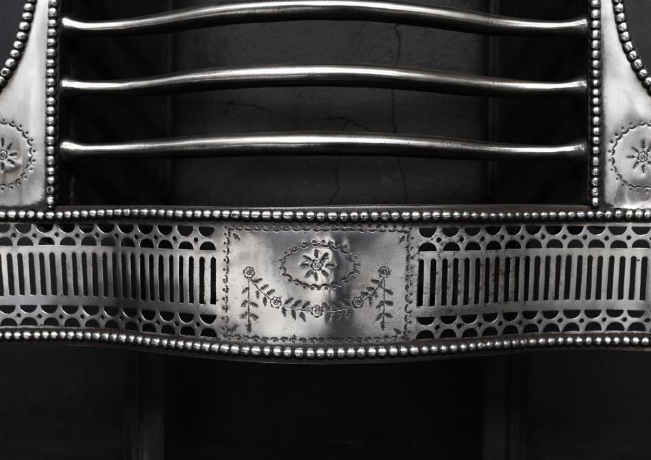 A polished steel firegrate in the Adam style