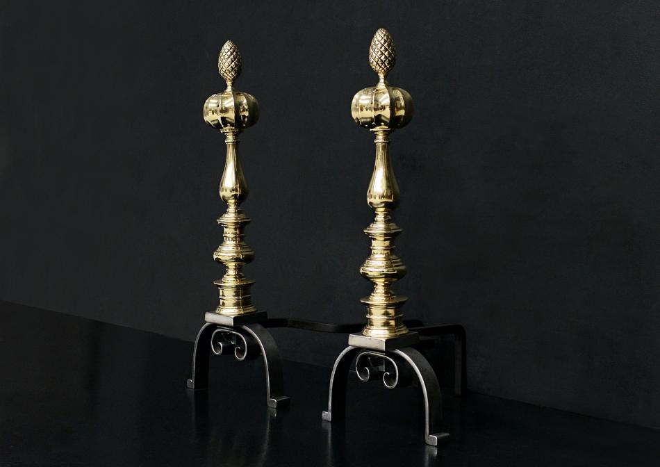 A pair of brass and steel firedogs