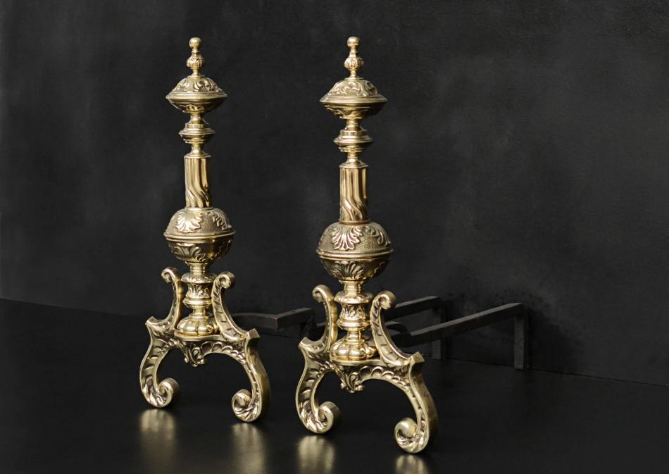 An ornate pair of brass firedogs