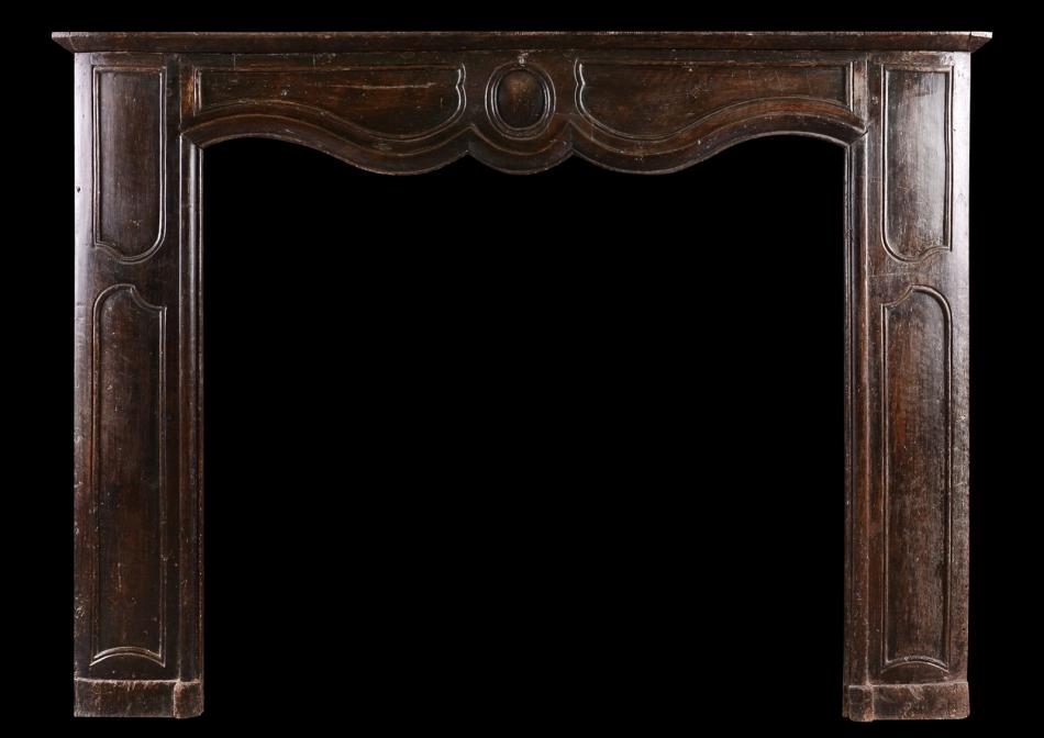 A transitional Louis XIV/XV walnut fireplace