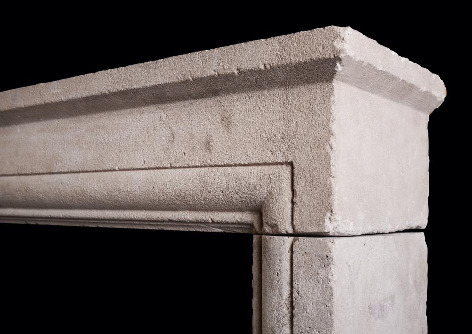 AN ARCHITECTURAL STONE FIREPLACE