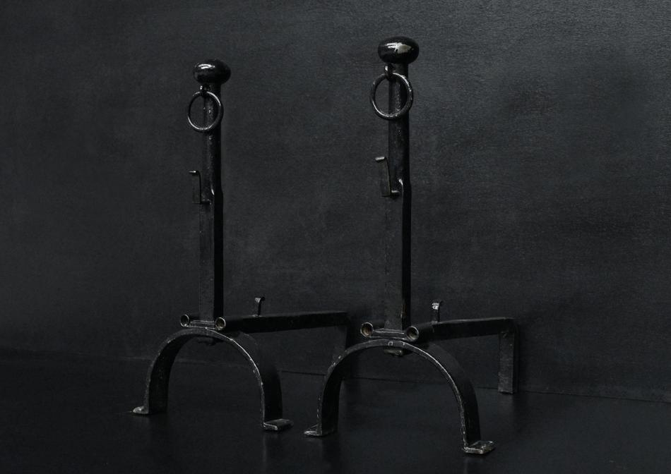 A pair of black wrought iron firedogs