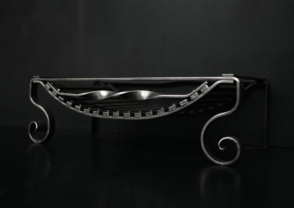 An English polished wrought iron firegrate