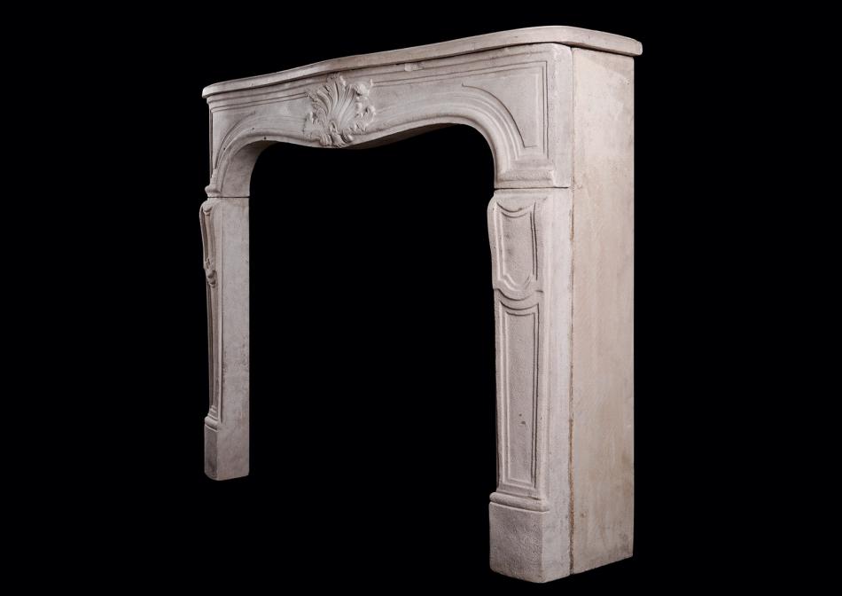 A Louis XV style limestone fireplace