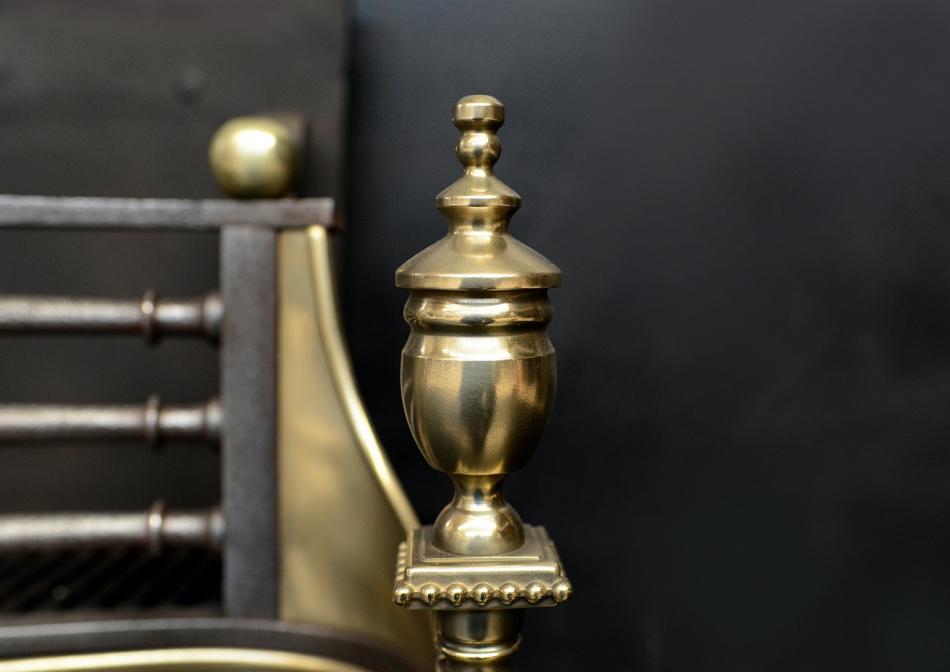 A Georgian style brass and steel firegrate